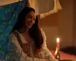 lavandière du 17ème siècle entourée de linge et de bougies